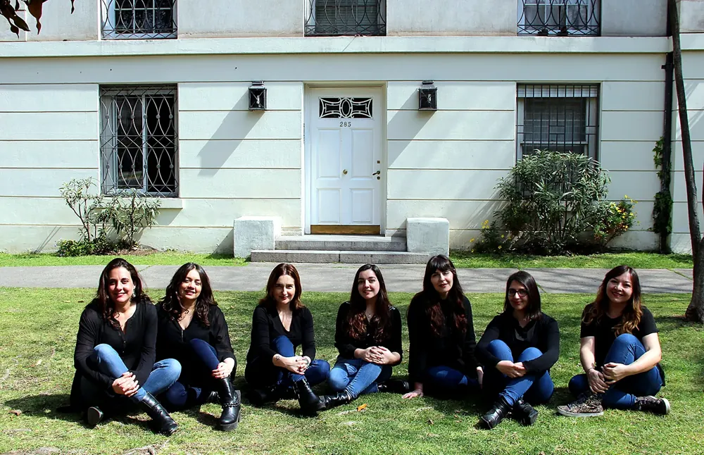 El equipo de Entrecomillas sentado en el pasto frente a la oficina